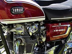 a red and white motorcycle parked next to other motorcycles