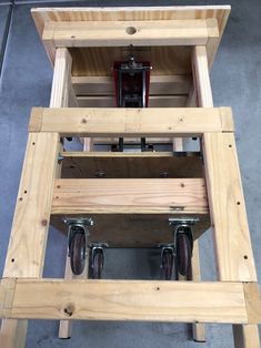 a wooden workbench with two wheels attached to the top and one on the bottom