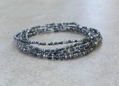 This is a lovely 36 inch long size 11/0 Morning Fog Tiny seed bead wrap bracelet. The colors used are shades of grey, clear, and silver. I've used stretch cord for this bracelet. 11/0 seed beads are 2mm by 2mm with the hole a diameter of 1mm. Gray Faceted Beads Bracelet As Gift, Gray Faceted Beads Bracelet For Gift, Gray Beaded Bracelets With Faceted Beads As A Gift, Gray Faceted Beaded Bracelets As Gift, Gray Faceted Beaded Bracelets For Gifts, Stackable Silver Wrap Bracelet With Round Beads, Silver Wrap Bracelet With Stackable Round Beads, Silver Stackable Wrap Bracelet With Round Beads, Silver Beaded Multi-strand Wrap Bracelet