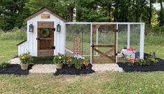 a chicken coop with flowers and plants in it