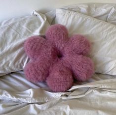 a pink teddy bear laying on top of a bed