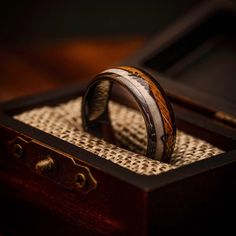 two wedding rings sitting in a wooden box