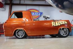 an orange truck parked inside of a garage