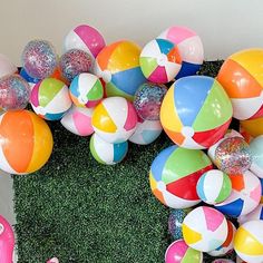 an arrangement of beach balls and fake grass