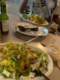 two people sitting at a table with plates of food