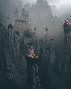 a man sitting on top of a rock cliff next to another person laying down in the fog