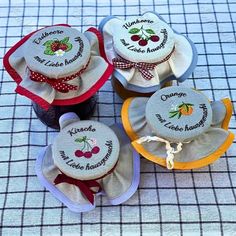 four small cupcakes with embroidered labels on them