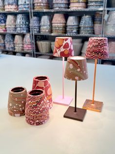 three lamps sitting on top of a table next to each other in front of shelves