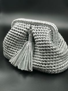 a woven purse with tassels on the inside is shown in black and white