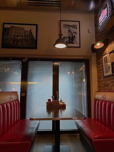 a restaurant with red booths and pictures hanging on the wall above it's windows