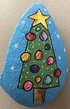 a painted rock with a christmas tree on it