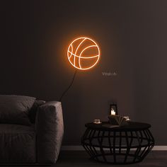 a living room with a couch, coffee table and neon basketball ball on the wall