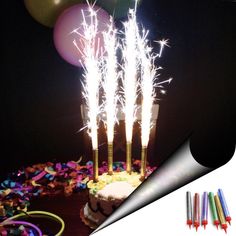 a birthday cake with sparklers and balloons on it is surrounded by confetti sticks