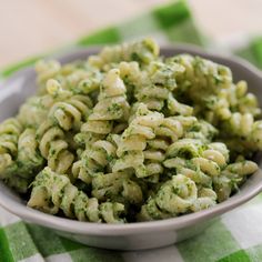 a bowl filled with pasta and broccoli on top of a checkered table cloth