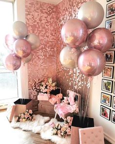 some balloons and pictures on the wall in a room with pink flowers, white fur rugs