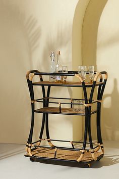 a bar cart with wine glasses and bottles on it