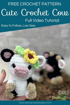 a small crochet cow with flowers on it's head is being held up