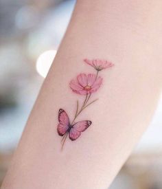 a pink flower with a butterfly tattoo on the left side of the arm and behind it is a line drawing