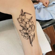 a black and white flower tattoo on the right arm, it looks like flowers are blooming