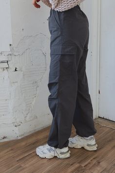 DETAILS: Our Slate Cargo Joggers are the ulitmate trendy jogger! These joggers feature a stretch elastic waistline, functional front pocket detail, and elastic ankle detail. There are two side pockets half way down the legs. These joggers have an adjustable elastic fastening at the waist and the ankles. These sweatpant joggers fit true to size and have a some stretch throughout. CONTENT & CARE: 100% Nylon. SIZE & FIT: Model is 5'5" The model is wearing a size Small. Fits true to size The Fabric Casual Gray Tapered Leg Cargo Pants, Gray Casual Joggers For Outdoor, Urban Relaxed Fit Cargo Joggers, Stretch Gray Cargo Pants With Pockets, Urban Relaxed Fit Cargo Style Joggers, Gray Stretch Cargo Pants With Pockets, Gray Athleisure Cargo Pants With Pockets, Sporty Gray Pants With Cargo Pockets, Sporty Cargo Pants With Comfort Waistband For Outdoor