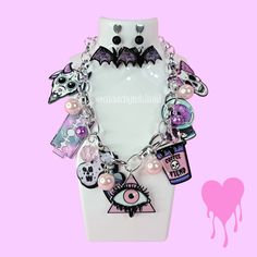 Step up your outfit's creepy cute factor with our one of a kind Pastel Goth statement necklace and earrings set! The intricate shapes and pearl details on the jewelry will make a stylish splash. Whether you pair it with a little black dress for a night out or a simple white tee for everyday wear, this necklace is guaranteed to be your new go-to accessory. Spooky season just got a whole lot cuter. **HAVE QUESTIONS?** ▶Checkout our FAQ Section or feel free to send us an Etsy Conversation! We try to return all messages within 24 hours. We process orders as entered so it it extremely important to check for accuracy prior to submitting the order. **CANCELATIONS** Request a cancellation within: 3 hours of purchase. No order cancellations after 24 hours of purchase. Visit our shop for more unique Edgy Halloween Jewelry For Costume Party, Cute Halloween Party Jewelry, Pink Punk Halloween Jewelry, Edgy Handmade Halloween Necklaces, Pink Gothic Jewelry For Halloween, Edgy Handmade Necklace For Halloween, Pink Punk Necklace For Party, Handmade Edgy Necklaces For Halloween, Pink Punk Style Necklace For Party