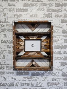 a white brick wall with a wooden frame on it and a monogrammed design in the middle