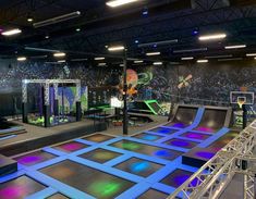 an indoor trampoline park with lights on