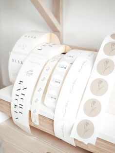 several rolls of white washi tape sitting on top of a wooden shelf next to each other