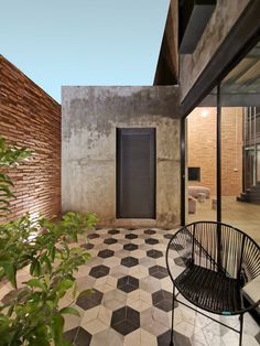 a black and white checkered tile floor next to a brick wall with an open door