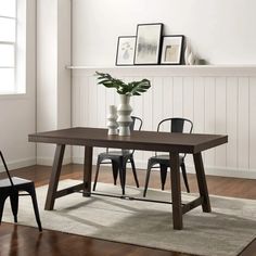 a dining table with two chairs and a vase on top of it in front of a fireplace