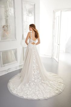 the back of a wedding dress with white flowers on it