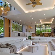 a living room filled with white furniture and lots of windows next to a dining table