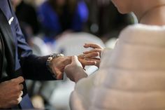 the bride and groom are exchanging their wedding rings