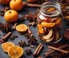 an assortment of spices and fruit in a glass jar with cinnamons, star anise, orange slices