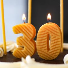 a birthday cake with candles in the shape of the number 30 on it and two lit candles