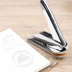 a pen sitting on top of a wooden table next to a notebook and pen holder