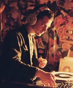 a man with headphones on working at a desk in front of a record player