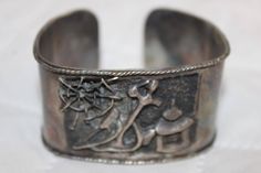 This RARE Vintage bracelet is a showstopper!  It has a picture story engraved with exquisite detail. It is from the 1940's making it a priceless piece of history! This is from a family estate and has been stored in an immaculate, smoke and pet free home. PHOTOS DO NOT DO IT JUSTICE! Please see ALL photos and ask questions before you purchase.  My grandmother was the most loving, honest person in the world and I want her beautiful legacy to live on. So, PLEASE ask questions before you purchase. PLEASE reach out to me first if there is a problem and give me an opportunity to resolve your concern. Thank you and I look forward to connecting with you! Shipping includes careful packaging, insurance, and signature required. Disclaimer: I am not a jeweler, dealer, buyer, nor do I own a store. I am Vintage Engraved Bracelets As Gift, Vintage Handmade Cuff Bracelet For Formal Occasions, Handmade Vintage Cuff Bracelet For Formal Events, Handmade Vintage Cuff Bracelet For Formal Occasions, Vintage Engraved Bracelets For Gift, Vintage Engraved Bracelet For Gift, Formal Vintage Handmade Cuff Bracelet, Antique Silver Engraved Bracelets For Anniversary, Antique Silver Bracelet Gift