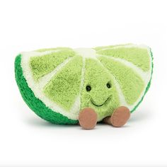 a green stuffed animal sitting on top of a white surface