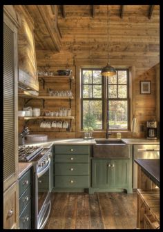 a kitchen with green cabinets and wooden walls