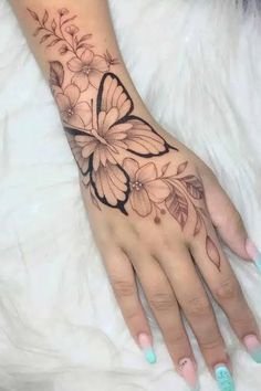 a woman's hand with a butterfly tattoo on it