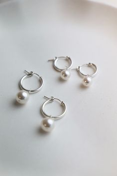 As seen on your favorite influencers, the Audrey Pearl Hoops are a staple in any jewelry collection. These earrings come in two sizes fit for any occasion. Available in small or large gold filled hoop with small and large organic shaped round pearl drop! Also available in Gold! Details: - Sterling silver hoops - Organic pearl - 2x13mm small hoop, 2x18.7mm large hoop - 10mm large pearl, 8mm small pearl SKU: E1260 Materials+Care Cheap Small Hoop Pearl Earrings For Everyday, Silver Pearl Hoop Earrings, Realistic Gifts, Silver Pearl Jewelry, Bachelorette Party Dress, Gold Filled Hoops, Jewellery Store, Pearl Hoop Earrings, Timeless Accessories