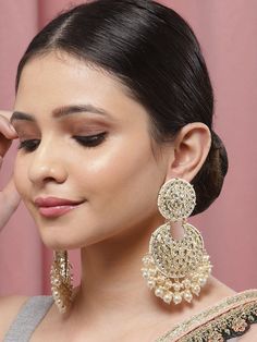 These exquisite gold-toned 2-layer crescent-shaped chandbali earrings come with kundan stone studs & beads, are gold-plated, and are secured with a post and back closure. These handcrafted chandbalis can be styled with any ethnic outfit for a dramatic impact, or an evening outfit to complete a dazzling look. Eitherway, complements are all yours! Product color may vary based on the monitor or screen you are using.See FAQ for more details. Size Length: 11 cm Details Material: BrassStones: Kundan & Gold Round Chandbalis With Stone Work, Chandbali Danglers For Party, Gold Heavy Chandbalis For Party, Kundan Chandbali Hoop Earrings For Celebration, Gold Plated Chandbali Chandelier Earrings For Celebration, Chandbali Earrings For Diwali Party, Party Chandbali Chandelier Earrings With Cutdana, Gold Kundan Hoop Earrings For Celebration, Gold Round Chandbalis For Party