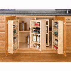 an open cabinet in the middle of a kitchen counter with spices and other items inside