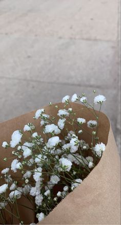 a brown paper bag filled with white flowers