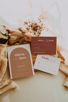 the wedding stationery is laid out on top of an unbuttoned blanket