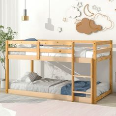 a wooden bunk bed sitting in a bedroom next to a wall with clouds on it