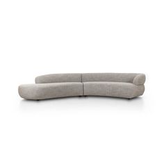 the curved sectional sofa is shown in light grey fabric, and sits on an angled surface