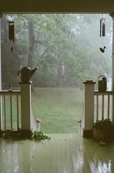 an open porch door with rain falling on the ground