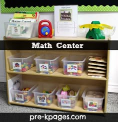 a book shelf filled with lots of books and plastic bins next to a sign that says math center